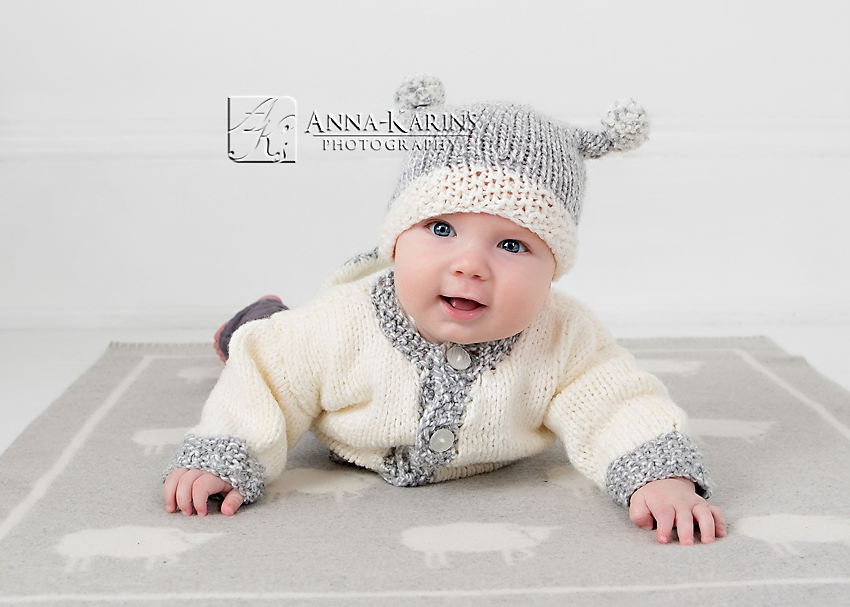 Baby boy in knitted hat and on a sheep blanket