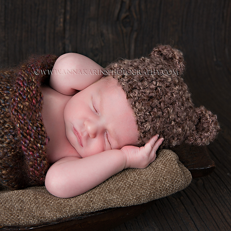 Newborn baby boy in knitted bear hat
