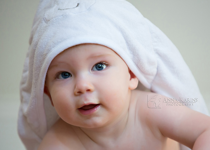 sweet blue eyed baby boy in hooded towel
