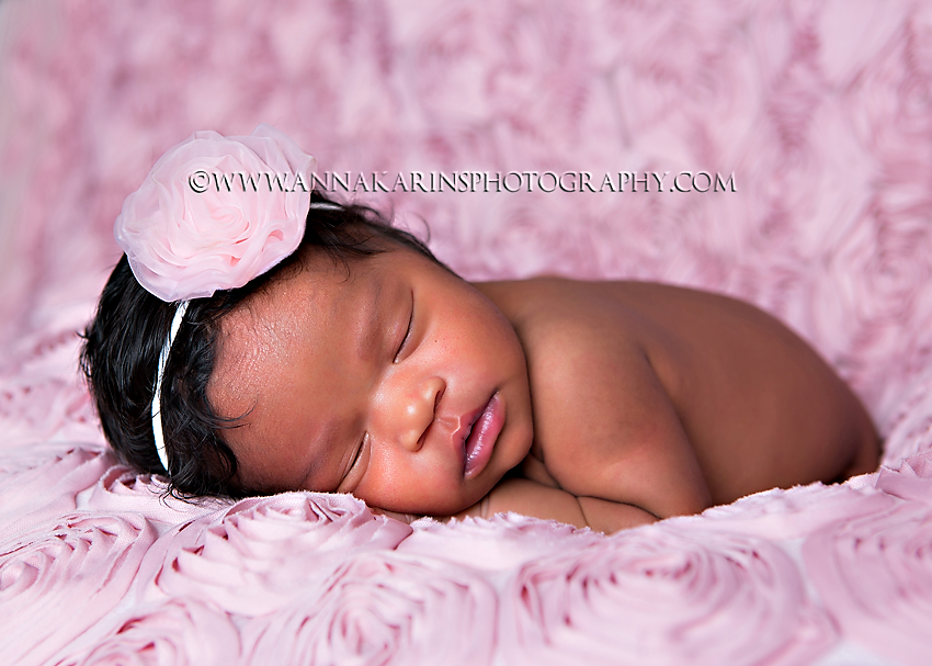 Beautiful newborn african american baby girl on pink 