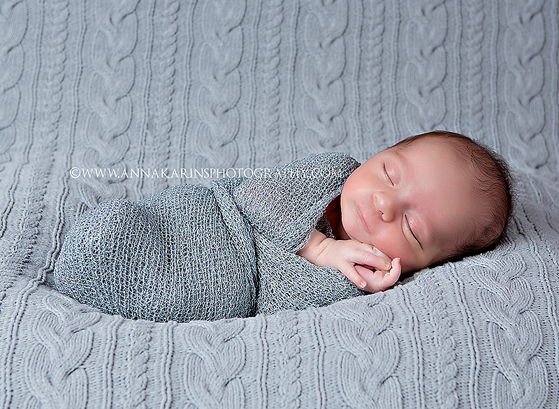 Newborn baby boy wrapped up, newborn baby on cable knit blanket