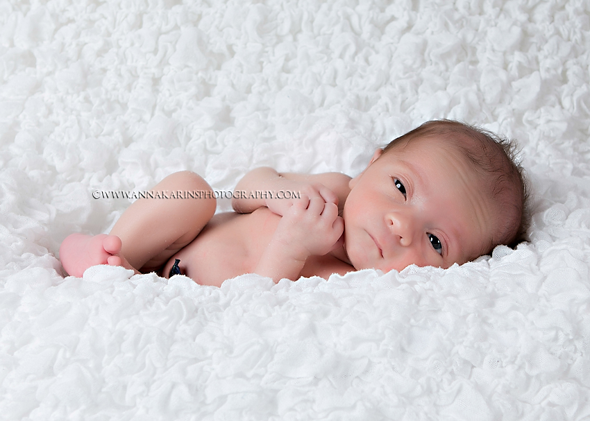 alert little newborn baby boy on white