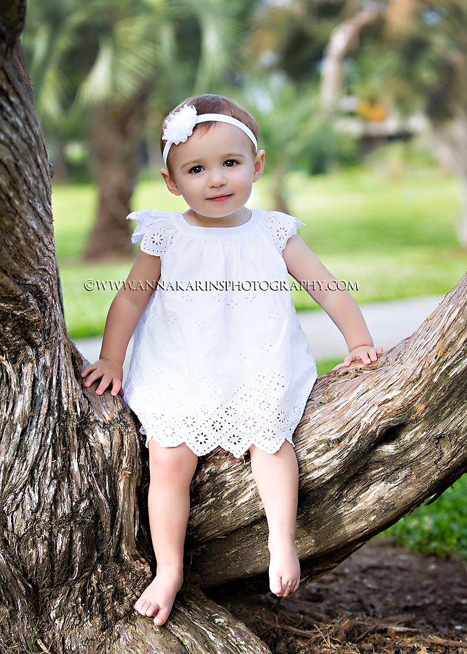 Little girl sitting in a tree